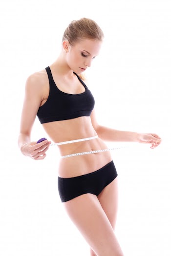 Beautiful woman measuring her waistline Free Photo