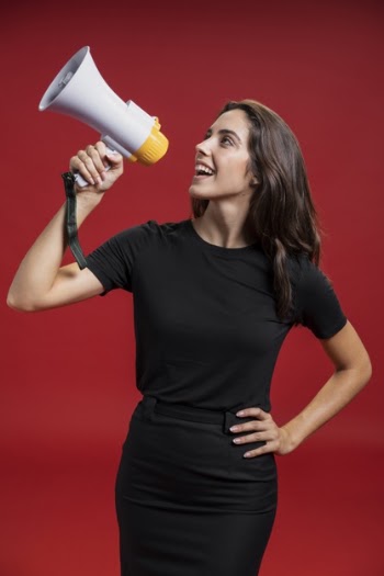 Beautiful woman shouting through a megaphone Free Photo