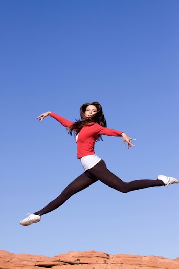 Beautiful young athletic woman jumping high
