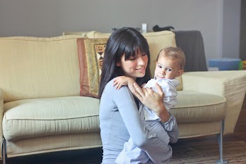  Beautiful young mother carrying her child in room 