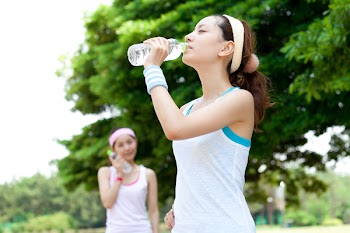 Beautiful young women drinking water at workout. Portrait of asian