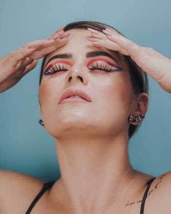 Beauty Female Model in Artistic Makeup Massages Her Forehead · Free Stock Photo