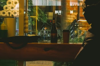 Beer Bottle Beside Solo Cup on Table