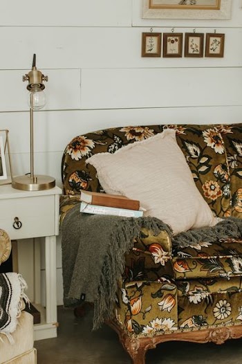 beige throw pillow, brass-colored table lamp, and two books