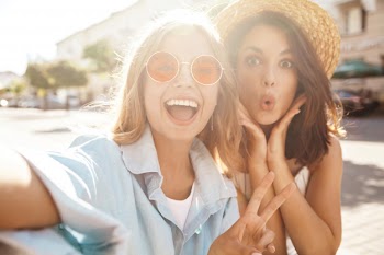 Best friends wearing stylish outfit and taking selfie on the street Free Photo