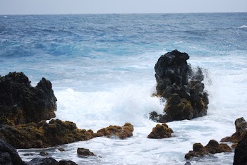 Big Rocks Surrounded by Body of Water Under Blue Sky at Daytime