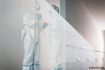 Biochemists in clean suits working in laboratory