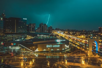 Bird's Eye View of Grey Building Near Road and Thunder Lighting Strike in Background
