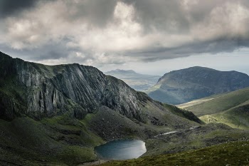 Bird's Eye View of Lake Near Mountains Under Cloudy Sky