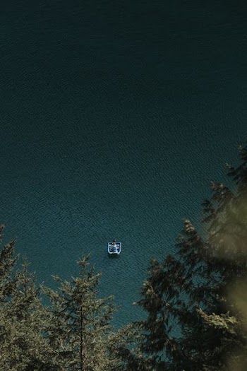bird's eye view of person on boat on calm body of water