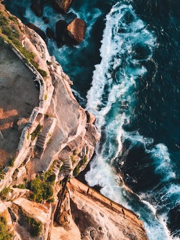 bird's eye view photography of cliff and sea waves