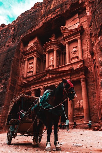 Black and Brown Horse Carriage Parked Beside Brown Temple