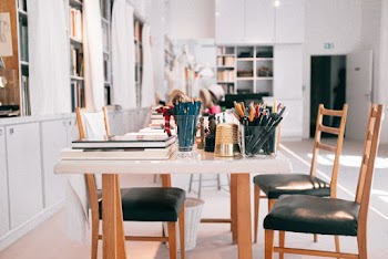 Black and Brown Padded Chairs Beside Table with Pens and Pencils
