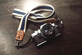Black and Gray Bridge Camera With White and Blue Lanyard