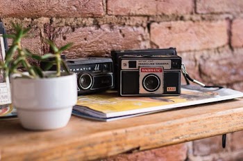 black and gray camera near white ceramic plant pot