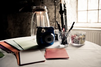 Black and Gray Camera on White Surface Near Glass Window
