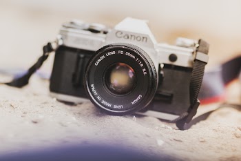 Black and Gray Canon Film Camera on Gray Soil