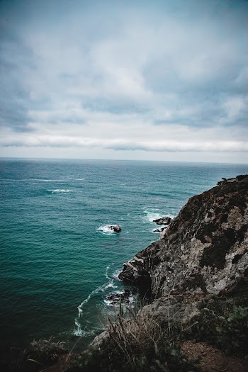 Black and Gray Cliff Towards Body of Water