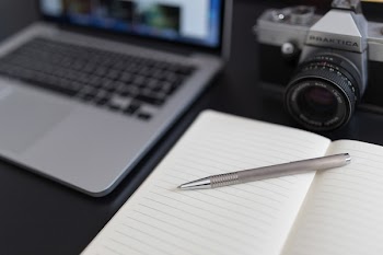 Black and Gray Dslr Camera Beside Macbook Pro
