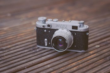 Black and Gray Film Camera on Brown Wooden Surface