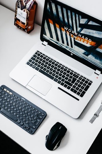 black and gray HP laptop beside black wireless mouse