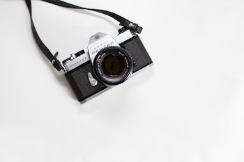 black and gray Pentax digital camera on white surface