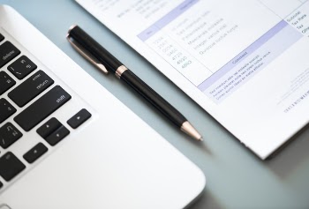 Black and Gray Twist Pen Beside Laptop Computer