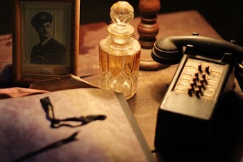 Black and Gray Vintage Telephone Near Glass Perfume Bottle