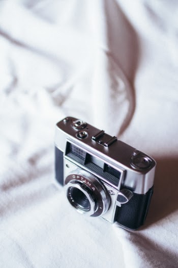 Black And Grey Camera On White Cloth