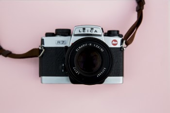 Black and Grey Leica Camera on Pink Background