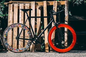 Black and Multicolored Bicycle Near Wood Fence