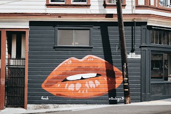 Black and Orange Lips Painted Building Wall