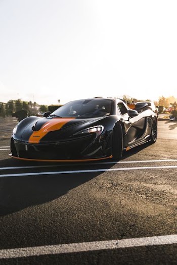 black and orange sports car under clear sky during daytime