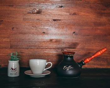 Black and Orange Turkish Coffee Pot on Table Near Cup and Saucer