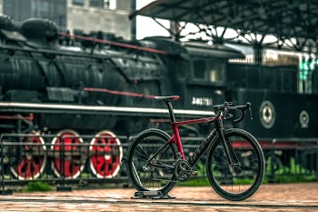 Black And Red Road Bike Near Black Train