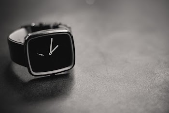 black and silver-colored analog watch showing 5:1