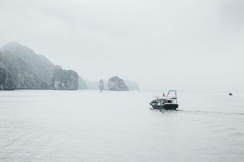 black and white boat near rock formation