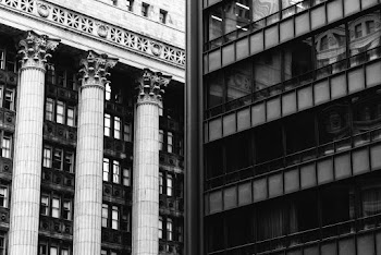 Black and White Photo of a Building Next to Pillars