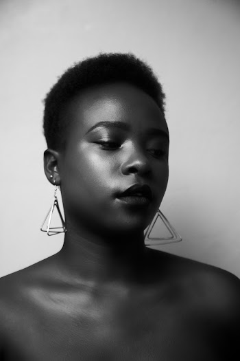 Black and White Photo of a Woman Wearing Triangular Earrings