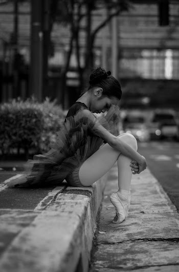 Black and White Photo of Ballerina Sitting on the Street