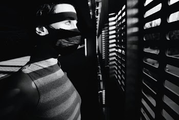 Black and White Photo of Person Looking at the Window