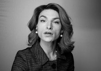 Black and White Photo of Woman in Collared Top Beside Wall
