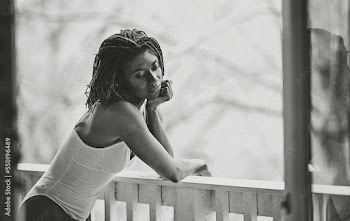 Black and white picture of Black woman in deep thought on patio 