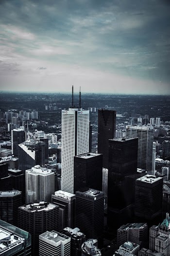 Black and White Tall Buildings Under Cloudy Sky