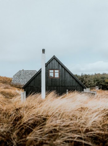 Black and White Wooden House on Brown Grass Field Under White Sky · Free Stock Photo