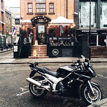 Black and White Yamah Sport Bike Parked Outside Belts Store Facade