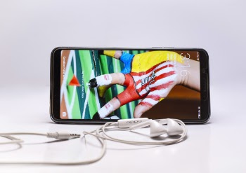 Black Android Smartphone Beside White Earphones