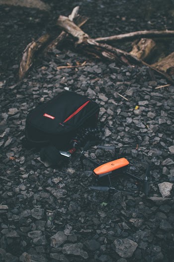 Black Backpack and Drone on Ground