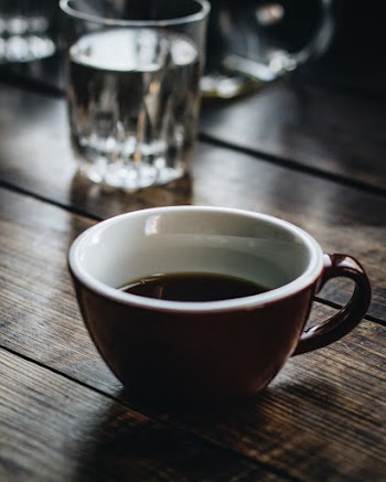 Black Beverage in Brown and White Ceramic Cup