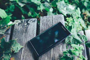 Black Blackberry Priv Smartphone on Brown Board
